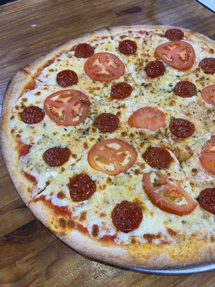 Pizza de pepperoni con tomate natural recién horneada
